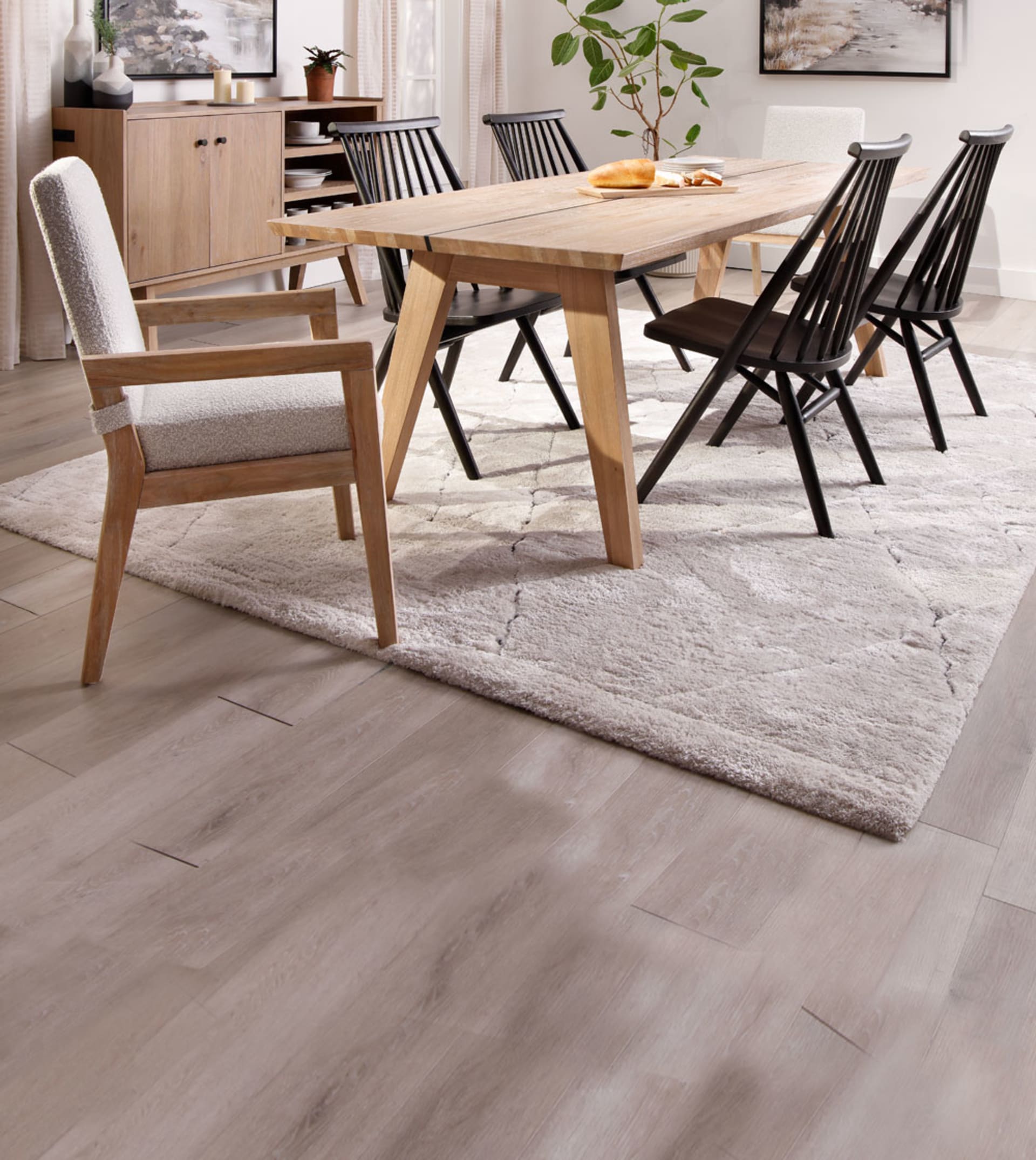 family eating at lIght colored dining set with black chairs in dining room